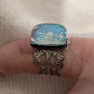 blue dichroic glass ring on an adjustable sterling silver band.